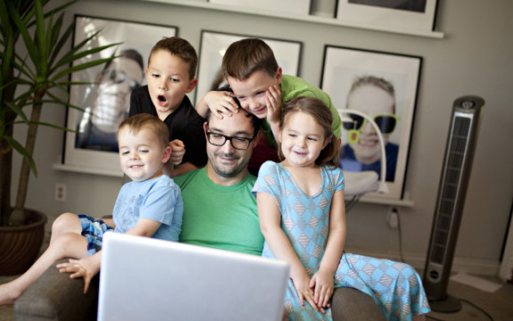 un père avec ses quatre enfants en visioconférence