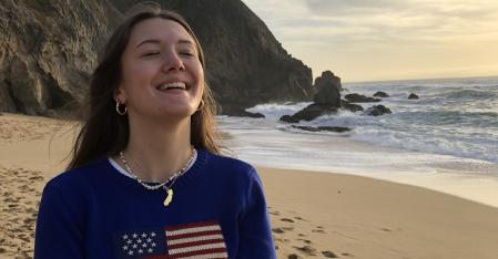 Au pair avec drapeau américain sur son pull, rigole sur la plage