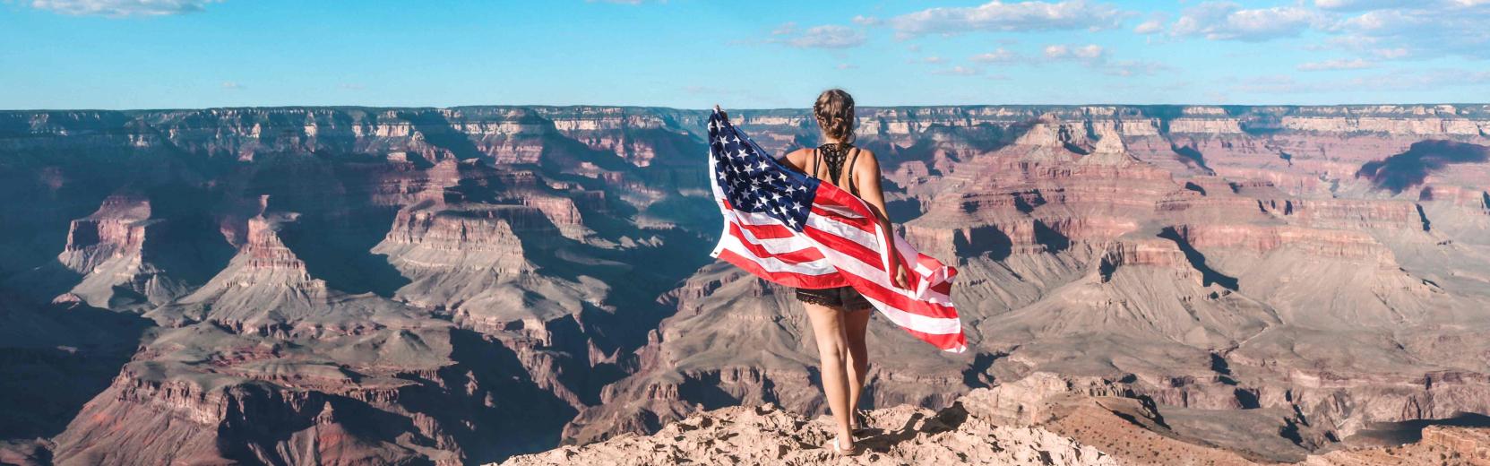 Au pair tenant un drapeau américain au Grand Canyon