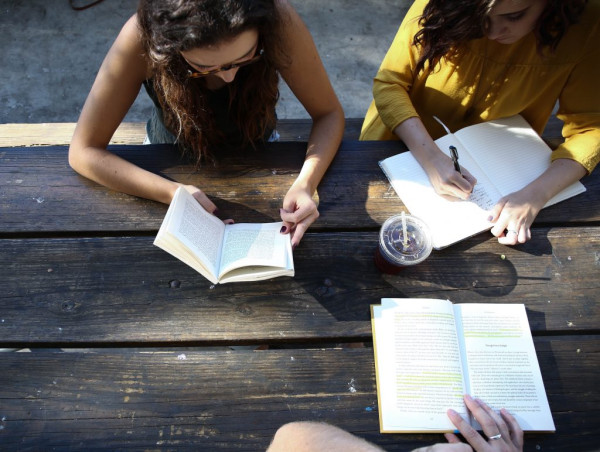 Trois étudiants sont assis à table et étudient ensemble