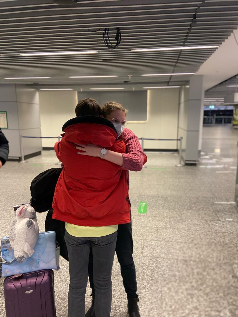 Laura embrassant sa famille d’accueil à l’aéroport à son arrivée