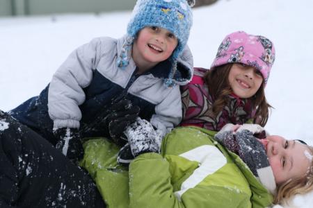 la fille au pair joue avec des enfants dans la neige