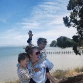 femme sur la plage portant deux enfants